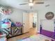 A bedroom with a view of the home and the hallway with a ceiling fan and a purple rug at 8717 Persea Ct, Trinity, FL 34655