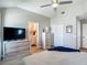 Bedroom featuring a ceiling fan, dresser with a TV, a closet, and an ensuite bathroom entrance at 8717 Persea Ct, Trinity, FL 34655