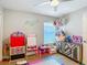 A bedroom area with an accent wall and a table for drawing with chairs and a ceiling fan at 8717 Persea Ct, Trinity, FL 34655