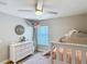 Bedroom with a bed, window, a chest of drawers, and wall decorations and a ceiling fan at 8717 Persea Ct, Trinity, FL 34655