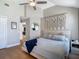Beautiful bedroom with wooden floors, ceiling fan, accent wall decor, and comfortable bedding at 8717 Persea Ct, Trinity, FL 34655