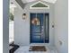Close-up of the inviting blue front door with decorative wreath and 'Home Sweet Home' doormat at 8717 Persea Ct, Trinity, FL 34655