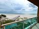 Scenic beach view from a condo balcony, with a pier and lush greenery at 880 Mandalay Ave # N311, Clearwater Beach, FL 33767