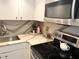 Bright kitchen featuring stainless steel appliances, white cabinetry, and attractive quartz countertops at 880 Mandalay Ave # N311, Clearwater Beach, FL 33767