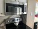 Stainless steel microwave, stove top, and cabinets in the kitchen at 880 Mandalay Ave # N311, Clearwater Beach, FL 33767