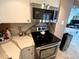 Contemporary kitchen showcasing stainless steel appliances, stone countertops, and white cabinets at 880 Mandalay Ave # N311, Clearwater Beach, FL 33767
