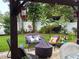 Inviting backyard patio featuring comfortable seating, a stylish fire pit, and charming hanging plants creating an outdoor oasis at 906 Ponce De Leon Blvd, Belleair, FL 33756