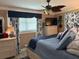 Comfortable bedroom with a ceiling fan, large window, and stylish blue and white patterned curtains at 906 Ponce De Leon Blvd, Belleair, FL 33756