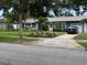 Attractive home with well-manicured lawn, brick driveway, and mature trees provides a welcoming setting at 906 Ponce De Leon Blvd, Belleair, FL 33756
