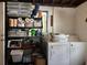 Functional laundry room with washer, dryer, shelving unit, and visible storage solutions for optimal organization at 906 Ponce De Leon Blvd, Belleair, FL 33756