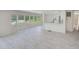 Open-concept living room with large windows, light gray flooring, and a breakfast bar overlooking the kitchen at 9790 66Th N St # 37, Pinellas Park, FL 33782