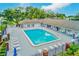 Inviting community pool with ample lounge chairs surrounded by lush greenery and fencing at 9790 66Th N St # 37, Pinellas Park, FL 33782