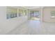 Bright sun room with large windows, sliding glass door, and light gray flooring at 9790 66Th N St # 37, Pinellas Park, FL 33782