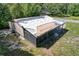 Aerial view of a house with roof in disrepair, an enclosed porch, and overgrown yard at 9910 Jerome Dr, New Port Richey, FL 34654