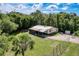 Aerial view of a single-story home surrounded by lush greenery on a partially sunny day at 9910 Jerome Dr, New Port Richey, FL 34654
