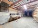 Unfinished basement with concrete floor, exposed beams, workbench, and shelving at 9910 Jerome Dr, New Port Richey, FL 34654