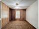 Bedroom with wood paneled walls, carpet flooring and a ceiling fan at 9910 Jerome Dr, New Port Richey, FL 34654