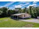 Exterior elevation of a single story home surrounded by greenery on a partially sunny day at 9910 Jerome Dr, New Port Richey, FL 34654