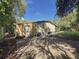 Exterior shows a weathered house with access door and a concrete driveway at 9910 Jerome Dr, New Port Richey, FL 34654