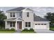 Charming two-story home featuring a light gray exterior, attached garage, and professionally landscaped front yard at 0 4Oth N Ave, St Petersburg, FL 33703