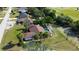 Aerial view of a house featuring a screened-in pool, lush landscaping, and a well-maintained lawn at 10365 Lynnhaven Rd, Spring Hill, FL 34608