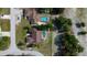 Aerial perspective of a property featuring a screened pool, complemented by lush trees and well-maintained lawns at 10365 Lynnhaven Rd, Spring Hill, FL 34608