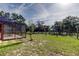 Backyard view with a screened-in pool area, grass, and mature trees at 10365 Lynnhaven Rd, Spring Hill, FL 34608
