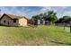 Backyard view featuring lush green grass, a screened-in pool and mature trees at 10365 Lynnhaven Rd, Spring Hill, FL 34608