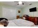 Bright bedroom featuring neutral colored walls, ceiling fan, and dresser with wall-mounted TV at 10365 Lynnhaven Rd, Spring Hill, FL 34608