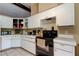 Bright kitchen with white cabinets and countertops with stove and tile floors at 10365 Lynnhaven Rd, Spring Hill, FL 34608