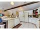 Bright kitchen featuring white cabinetry, tile flooring and an eat-in bar area at 10365 Lynnhaven Rd, Spring Hill, FL 34608