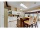 Sunlit kitchen featuring a skylight, breakfast bar, and ample cabinet space at 10365 Lynnhaven Rd, Spring Hill, FL 34608