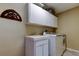 Convenient laundry room featuring a sink, washer, dryer, and ample cabinet space at 10365 Lynnhaven Rd, Spring Hill, FL 34608
