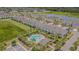 Aerial view showcasing the townhouse exteriors, a pool, and lakeside in a Primary-planned community at 10830 Verawood Dr, Riverview, FL 33579
