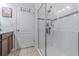 This bathroom has a glass-enclosed shower, white tiled walls and floor, and mosaic accent tiles at 10830 Verawood Dr, Riverview, FL 33579