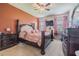 This primary bedroom boasts dark wood furniture, an orange accent wall, and lots of natural light at 10830 Verawood Dr, Riverview, FL 33579
