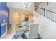 Elegant dining area featuring a glass table with seating, white chairs, and contemporary decor with stairs in background at 10830 Verawood Dr, Riverview, FL 33579