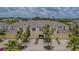 Inviting townhome exterior showcasing charming architecture, individual garages, and tropical landscaping under a partly cloudy sky at 10830 Verawood Dr, Riverview, FL 33579
