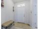 Bright foyer featuring a white front door, neutral decor, and a stylish bench for comfortable seating at 10830 Verawood Dr, Riverview, FL 33579