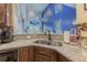 Kitchen area showcasing stainless steel double sink, granite countertop, and view of dining room with modern accents at 10830 Verawood Dr, Riverview, FL 33579