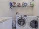 Practical laundry room features washer, dryer, freezer, storage shelf, and white walls at 10830 Verawood Dr, Riverview, FL 33579