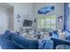 Bright living room with blue couches, tall ceilings, and a sliding glass door with outside view at 10830 Verawood Dr, Riverview, FL 33579