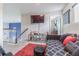 Cozy upstairs loft with a black futon, red rug, TV, and a view of the staircase and downstairs living area at 10830 Verawood Dr, Riverview, FL 33579