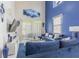 Spacious living room with tall ceilings, ample natural light, plush blue seating, and stylish decor at 10830 Verawood Dr, Riverview, FL 33579