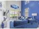 Bright living room featuring cozy blue sofas, high ceilings, and a sliding glass door with views of open outdoor space at 10830 Verawood Dr, Riverview, FL 33579