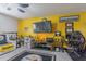 Living room with bright yellow walls, Steelers memorabilia, desk with computer, TV, and white leather couch at 10830 Verawood Dr, Riverview, FL 33579