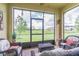 This screened-in patio has wicker furniture and a beautiful view of the landscaped backyard at 10830 Verawood Dr, Riverview, FL 33579