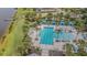Aerial view of large community pool with blue cabanas and ample lounging areas at 10830 Verawood Dr, Riverview, FL 33579