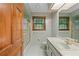 Vintage bathroom with tiled walls, vanity, and a combination tub and shower at 11159 Cindy Dr, Brooksville, FL 34601