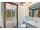 Light blue bathroom with marble countertops and open view of the screened in pool at 11159 Cindy Dr, Brooksville, FL 34601